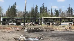 Kondisi bus yang membawa pengungsi Suriah usai terkena serangan bom di Rasyidin, Aleppo, Suriah, Minggu (16/4). Dalam insiden itu, ledakan bom menghantam konvoi bus-bus padat penumpang yang mengangkut para pengungsi. (AFP Photo/Omar Haj Kadour)