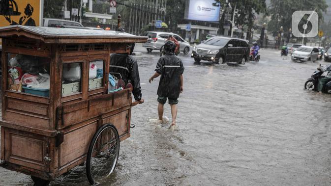 Kondisi genangan air di Jalan Medan Merdeka Timur, Jakarta, Jumat (24/1/2020). Hujan deras yang mengguyur Jakarta sejak pagi tadi mengakibatkan genangan air di Jalan Medan Merdeka Timur. (Liputan6.com/Faizal Fanani)