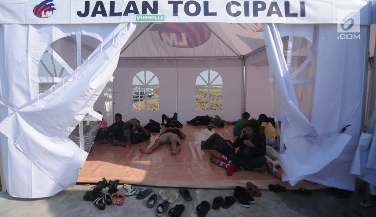 Sejumlah pemudik beristirahat di tenda "rest area alternatif" Km 153 Cipali, Jawa Barat, Rabu (21/6). Untuk melepas lelah, sebagian pemudik berhenti dan beraktivitas di sejumlah area peristirahatan sementara yang tersedia. (Liputan6.com/Gempur M Surya)