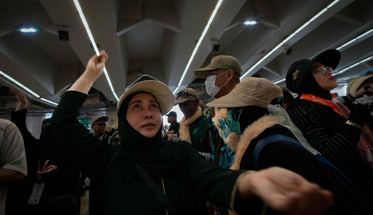 Jemaah Muslim melemparkan kerikil ke tiang-tiang sebagai simbol pelemparan batu ke setan pada hari kedua ritual, salah satu upacara terakhir ibadah haji tahunan, di Mina, Arab Saudi, Kamis 28 Mei 2026. (AP Photo/Altaf Qadri)