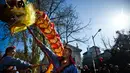 Sejumlah orang membawakan tarian Naga saat perayaan menjelang tahun baru China di Lisbon, Portugal (21/1).  Menjelang Imlek, warga keturunan Tionghoa di Portugal juga merayakannya dengan karnaval di sekitar Kota Lisbon. (AFP/Patricia De Melo Moreira)