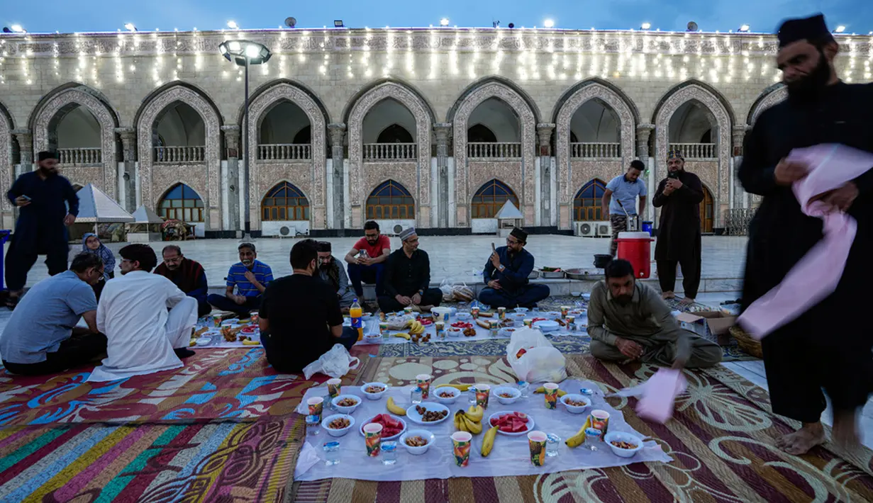Mereka menyantap makanan dan minuman yang dihidangkan di depan mereka. (AP Photo/Hadi Mizban)