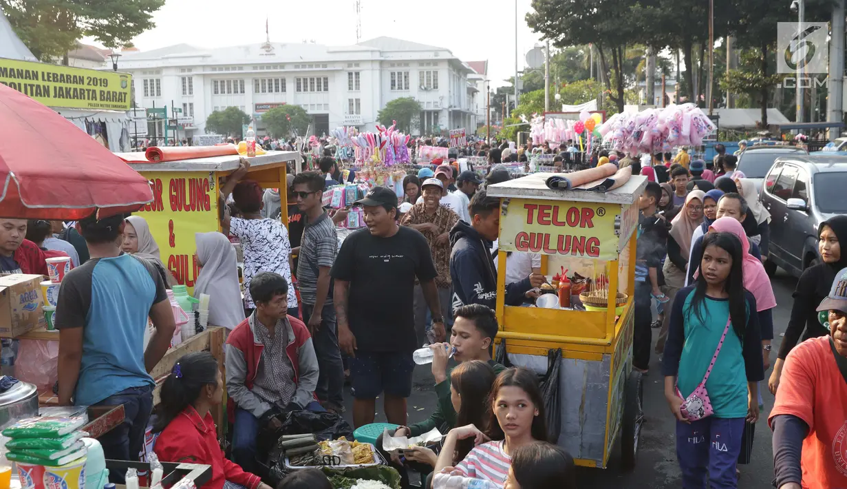 Warga berjalan di depan pedagang kaki lima yang berdagang di sebagian ruas Jalan Lada samping Kawasan Wisata Museum Fatahillah, Jakarta, Selasa (11/6/2019). Kondisi ini menyulitkan wisatawan pejalan kaki dan membuat arus lalu lintas di Jalan Lada menjadi semrawut. (Liputan6.com/Helmi Fithriansyah)