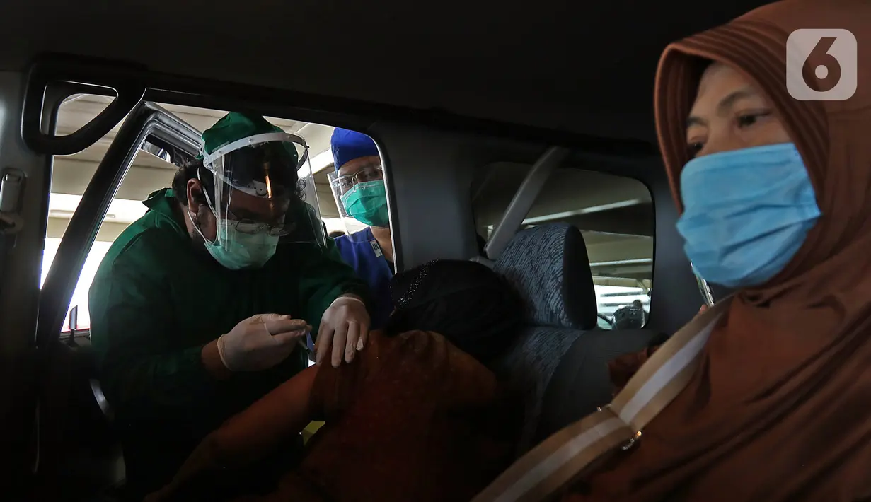 Petugas medis menyuntikkan vaksin COVID-19 kepada lansia secara drive thru di RSUI, Depok, Jawa Barat, Kamis (25/3/2021). Program Sentra Vaksinasi Indonesia Bangkit untuk lansia yang berdomisili di Depok dan sekitarnya ini digelar secara drive thru. (Liputan6.com/Herman Zakharia)