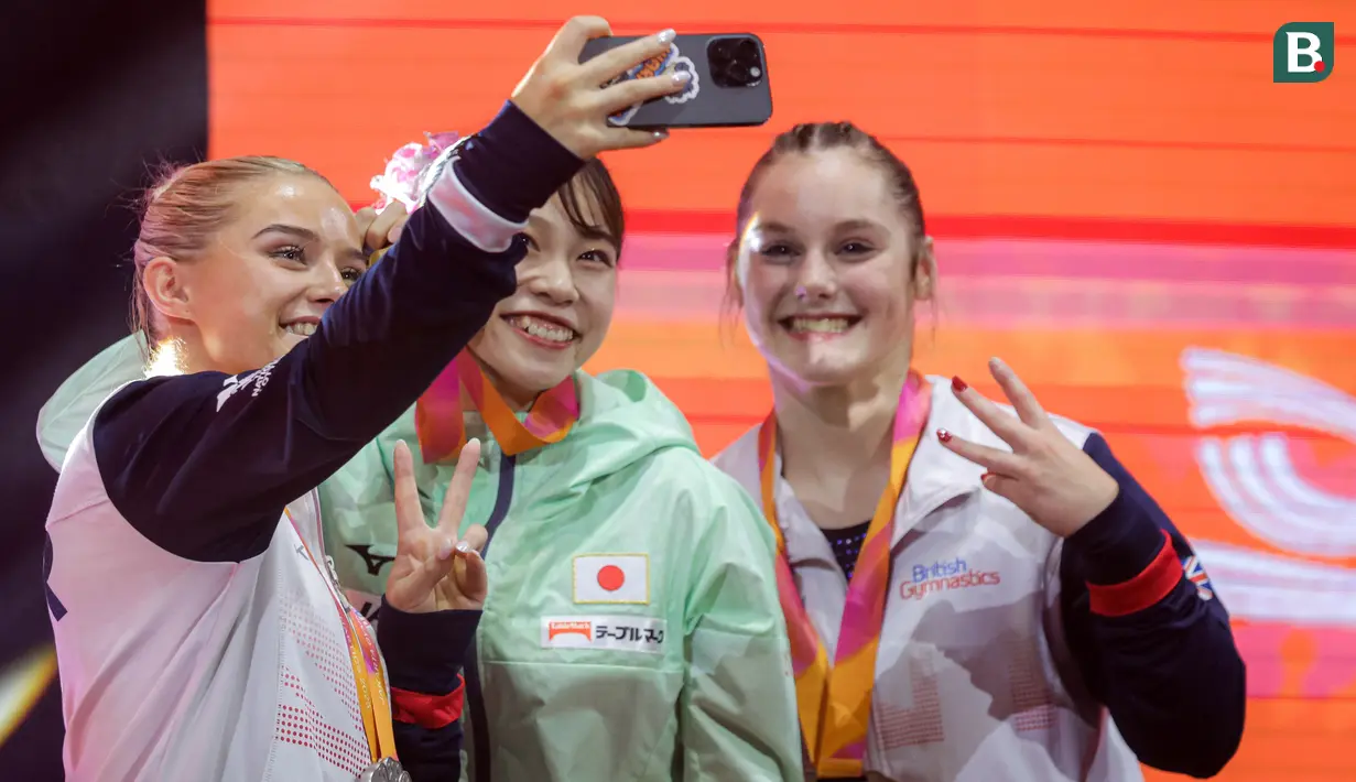 <p>Pesenam Inggris, Ruby Evans (kiri) berswafoto bersama pesenam Jepang, Aiko Sugihara (tengah) dan kompatriotnya, Abigail Martin saat podium aparatus putri nomor senam lantai Kejuaraan Dunia Gimnastik 2025 di Indonesia Arena, Senayan, Jakarta, Sabtu (25/10/2025). (Bola.com/Bagaskara Lazuardi)</p>
