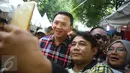 Warga berselfie dengan Cagub DKI Jakarta, Basuki T Purnama saat acara "Bersyukur Jakarta", Jumat (20/1). Dalam acara yang berbentuk bakti sosial dan pasar murah tersebut, terdapat hiburan dan permainan anak. (Liputan6.com/Immanuel Antonius)
