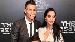 Bintang Real Madrid, Cristiano Ronaldo bersama pasangannya, Georgina Rodriguez dan sang putra, Cristiano Ronaldo Jr berpose setibanya di karpet hijau acara The Best FIFA Football Awards, London, Senin (23/10). (Glyn KIRK/AFP)