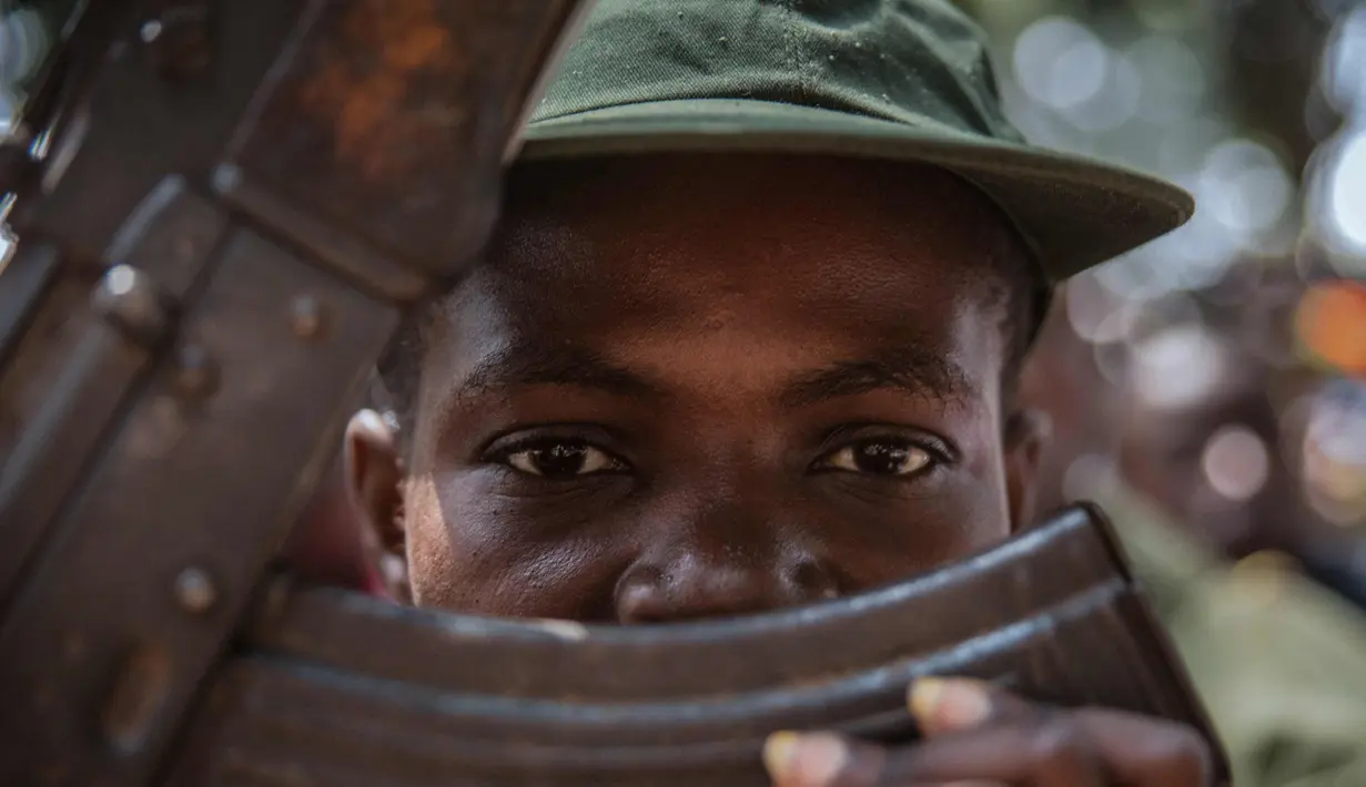 Seorang tentara anak yang baru dibebaskan menghadiri upacara pelepasan di Yambio, Sudan Selatan, (7/2). Pembebasan tentara anak kali ini menjadi yang pertama kali dengan jumlah anak perempuan terbanyak.  (AFP PHOTO/Stefanie Glinski)