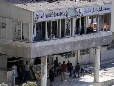 Orang-orang berkumpul di pintu masuk Rumah Sakit Jabal Amel yang rusak, setelah serangan udara Israel pada Senin (1/6) yang menghantam gedung di dekatnya, di kota pelabuhan selatan Tyre, Lebanon, Selasa 2 Juni 2026. (AP Photo/Mohammed Zaatari)
