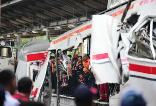 Para pekerja dan petugas penyelamat memeriksa kondisi salah satu gerbong Kereta Rel Listrik (KRL) Commuter Line yang mengalami kecelakaan di Stasiun Bekasi Timur, Bekasi, Jawa Barat, Selasa 28 April 2026. (AP Photo/Tatan Syuflana)