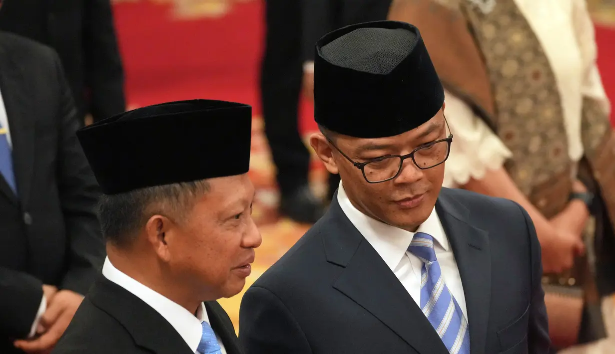 Menteri Luar Negeri Indonesia, Sugiono (kanan) berbicara dengan Menteri Dalam Negeri Tito Karnavian sebelum dimulainya upacara pengambilan sumpah para menteri baru di istana kepresidenan di Jakarta, Senin 21 Oktober 2024. (AP Photo/Achmad Ibrahim)