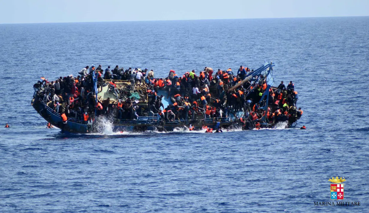 Angkatan Laut (AL) Italia merilis gambar sebuah perahu yang berisi para migran terbalik di lepas pantai Libya, Rabu (25/5). Tujuh orang tewas tenggelam, sementara 500 orang lainnya berhasil diselamatkan dalam insiden tersebut (STR/AFP MARINA MILITARE/AFP)