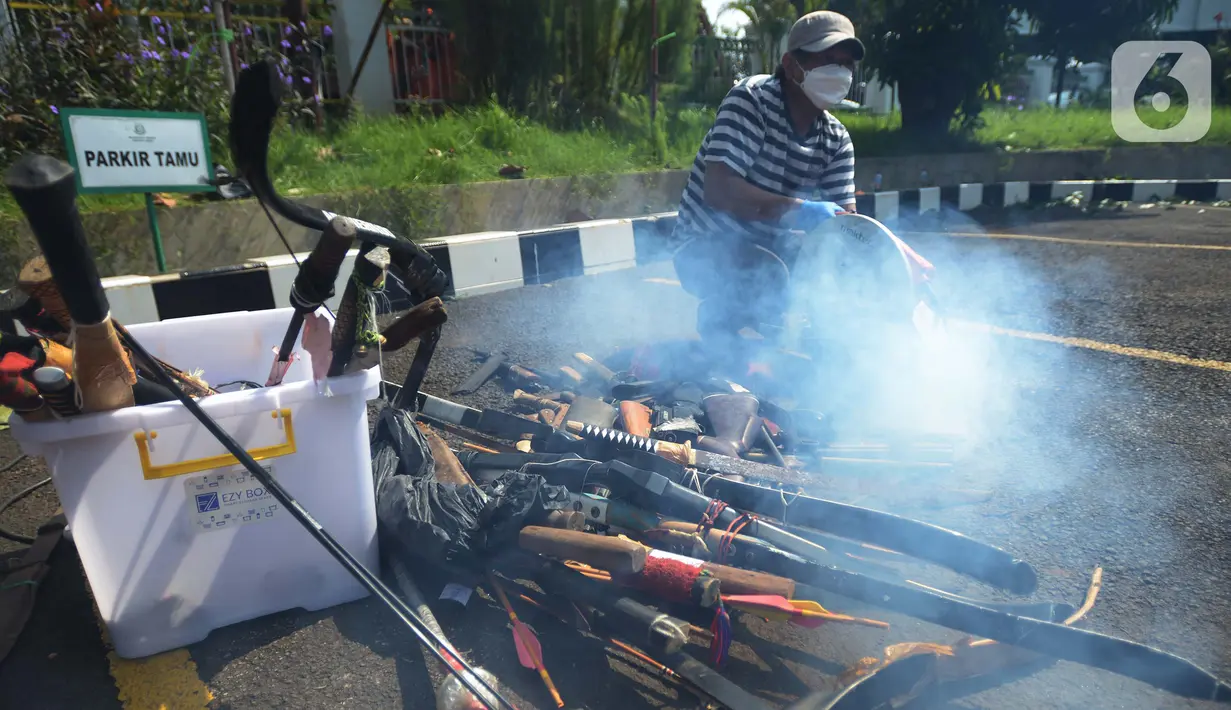 Petugas memotong  hasil sitaan saat pemusnahan barang bukti di depan Kantor Kejaksaan Negeri Jakarta Timur, Selasa (5/7/2022). Kejaksaan Negeri Jakarta Timur memusnahkan barang bukti dari 302 perkara periode Januari sampai Juni 2022 dengan rincian perkara Terorisme, perkara Narkotika, perkara Cukai dan obat tanpa ijin edar. (merdeka.com/Imam Buhori)