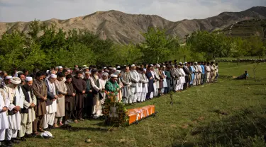 Teman dan kerabat mensalatkan jenazah kepala fotografer Agence France Presse (AFP) Afghanistan Shah Marai Faizi di Gul Dara, Kabul (30/4). (Andrew Quilty / POOL / AFP)