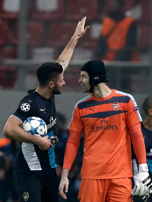 Olivier Giroud merayakan dengan rekan setimnya kiper Petr Cech usai pertandingan melawan Olympiakos di Stadion Georgios Karaiskakis, Piraeus, Yunani  (9/12). Arsenal menang atas Olympiakos dengan skor 3-0. (REUTERS/Alkis Konstantinidis)