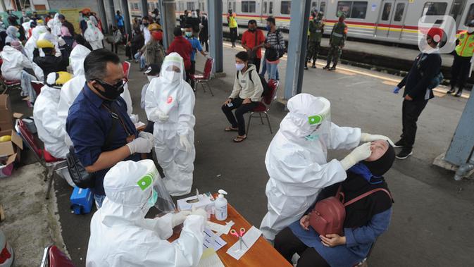 Paramedis mengambil sampel penumpang KRL Commuter Line saat tes swab di Stasiun Bojonggeder, Jawa Barat, Senin (11/05/2020). Tes swab dan rapid dilakaukan sebagai salah satu metode untuk mendeteksi dan mencegah penyebaran Covid-19 di moda transportasi KRL Commuter Line. (merdeka.com/Arie Basuki)