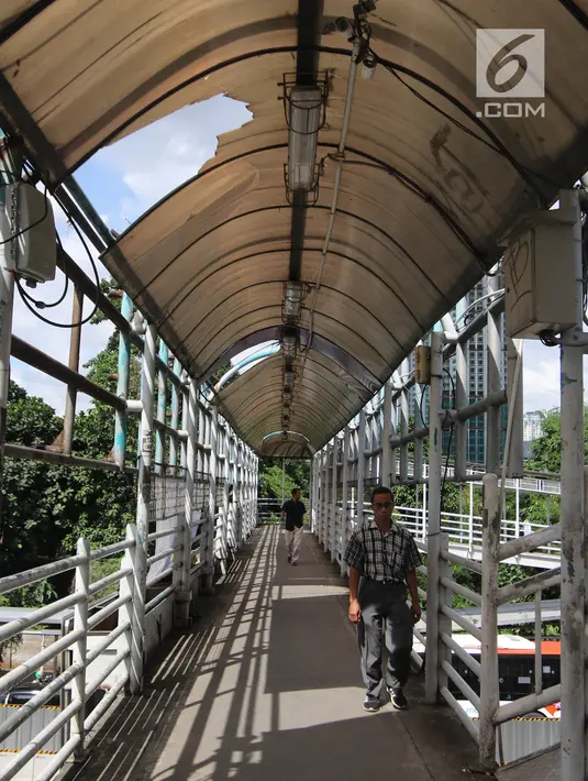 Pejalan kaki melintasi jembatan penyeberangan orang (JPO) di Jalan Sudirman, Jakarta, Jumat (27/4). Nantinya, JPO sepanjang Jalan Sudirman hingga Thamrin akan direvitalisasi dengan tema Asian Games. (Liputan6.com/Arya Manggala)