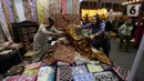 Pedagang kain melayani pembeli dalam pameran Inacraft on October di JCC, Jakarta, Rabu (4/10/2023). Salah satu pameran produk kerajinan terbesar di Asia Tenggara itu diikuti lebih dari 700 peserta yang berlangsung hingga 8 Oktober mendatang. (Liputan6.com/Faizal Fanani)