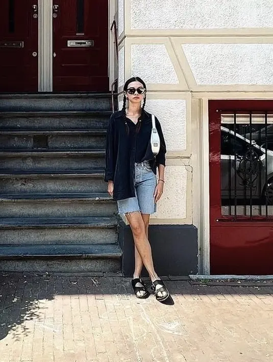 Yuki juga tampil dengan kemeja hitam lengan panjang, dipadukan celana denimnya. Serta sandal hitam dan membawa shoulder bag putih.  [Instagram/@Yukikt]