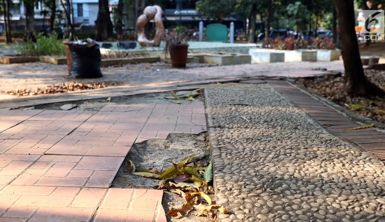 Kondisi jalan di Taman Puring yang berada di kawasan Jakarta Selatan, Minggu (15/9/2019). Nampak kondisi taman memprihatinkan, sejumlah bagian taman terlihat rusak dan kotor. (Liputan6.com/Helmi Fithriansyah)