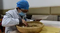 Apoteker meracik obat tradisional China di Rumah Sakit Afiliasi Pertama Universitas Kedokteran China di Hefei, 24 Februari 2020. RS itu bertanggung jawab meracik, merebus dan mengirim obat tradisional China ke tujuh rumah sakit yang ditunjuk untuk merawat pasien COVID-19 di Hefei. (Xinhua/Zhou Mu)