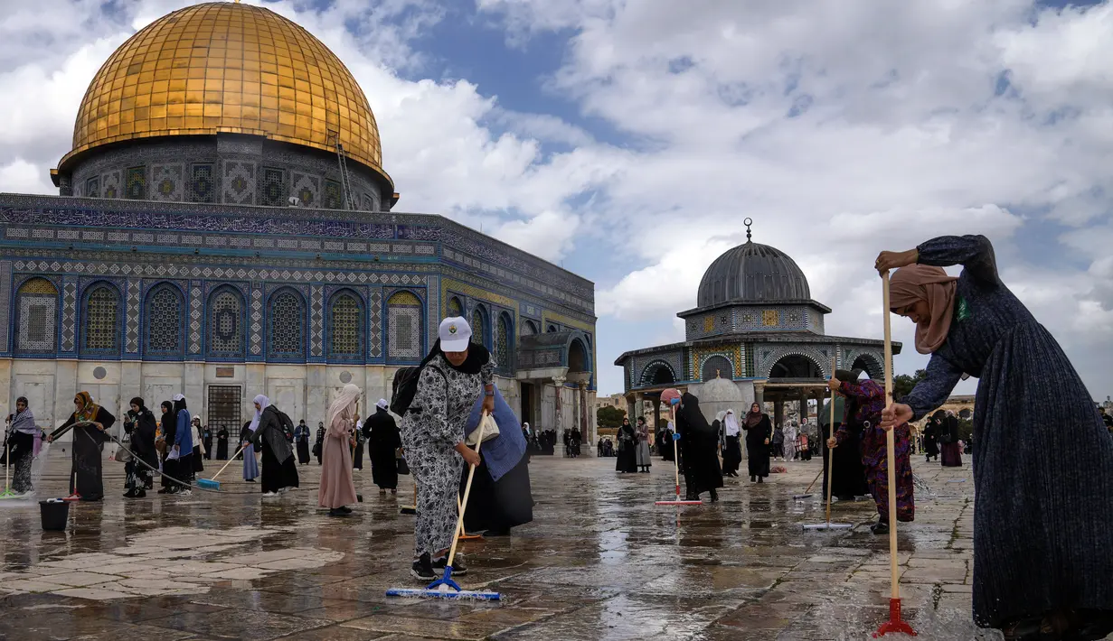 Relawan Palestina membersihkan tanah di luar Masjid Dome of Rock di Kompleks Masjid Al Aqsa, Kota Tua Yerusalem, Sabtu (18/3/2023). (AP Photo/Mahmoud Illean)