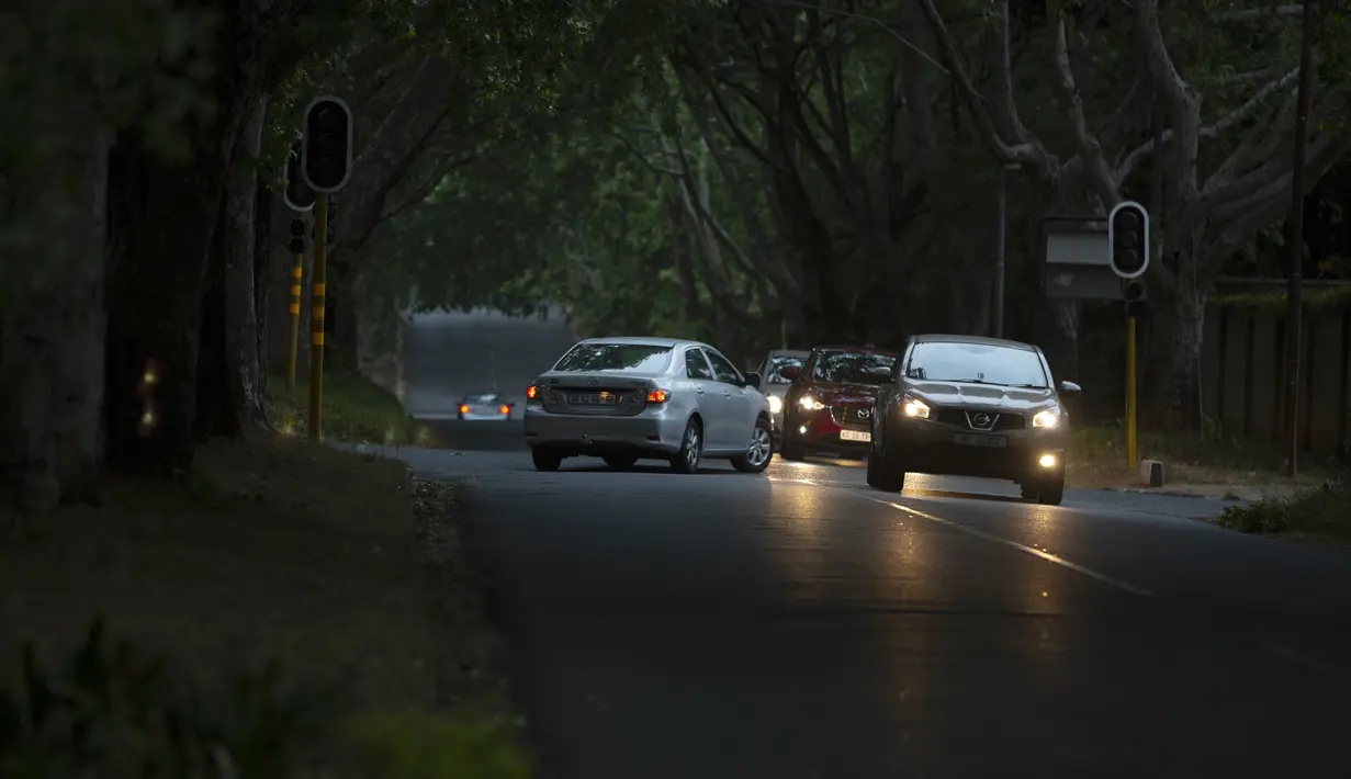 Mobil melewati persimpangan yang dikendalikan lampu lalu lintas selama pemadaman listrik di Johannesburg, Rabu, 21 September 2022. Sebagian besar warga Afrika Selatan harus hidup tanpa listrik selama enam jam per hari seiring memburuknya krisis energi. (AP Photo/Denis Farrell)