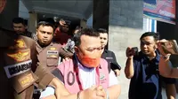 Mantan Direktur PDAM Bone Bolango, Yusar Laya saat digiring ke mobil tahanan (Arfandi Ibrahim/Liputan6.com)