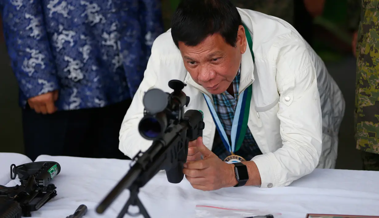 Presiden Filipina Rodrigo Duterte mencoba senapan sniper CS / LR4A buatan China di Clark Airbase di Filipina (28/6). Bantuan militer tersebut akan digunakan untuk melawan ancaman terorisme dan pembajakan dari kelompok militan. (AP Photo/Bullit Marquez)