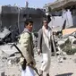 Pemberontak Houthi memeriksa lokasi serangan udara Saudi di kota Saada (30/3). Situasi Yaman yang memburuk memaksa PBB menarik seluruh staf internasionalnya dari sana. (Reuters/VOA News)