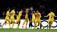 Pemain Barcelona merayakan gol di depan pemain Paris Saint-Germain, Kylian Mbappe, pada laga leg pertama perempat final Liga Champions di Stadion Parc des Princes, Kamis (11/4/2024). Berkat kemenangan ini, Barcelona punya modal apik untuk memainkan leg kedua di kandang mereka pada pekan depan. (AFP/Anne-Christine Poujoulat)