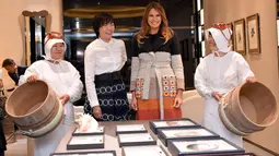 Ibu Negara AS Melania Trump (kedua kanan) didampingi Istri PM Jepang,  Akie Abe (ketiga kanan) tersenyum saat mengunjungi toko pembuat perhiasan mutiara Jepang di distrik Ginza, Tokyo (5/11). (AFP Photo/Pool/Katsumi Kasahara)