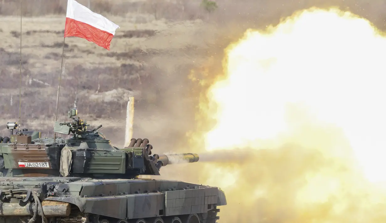 Tank Polandia menembak selama latihan militer NATO Crystal arrow 2022 di pangkalan militer Adazi, Latvia (11/3/2022). 2.800 tentara dari berbagai negara mengikuti pelatihan interoperabilitas selama operasi militer taktis, termasuk demonstrasi kemampuan musim dingin. (Martins Zilgalvis/F64 via AP)