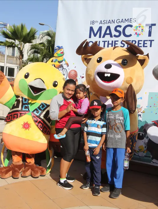 Warga berfoto dengan maskot Asian Games 2018 Bhin-Bhin (kiri) dan Atung saat hari bebas kendaraan bermotor di kawasan Bundaran HI, Jakarta, Minggu (1/4). (Liputan6.com/Arya Manggala)