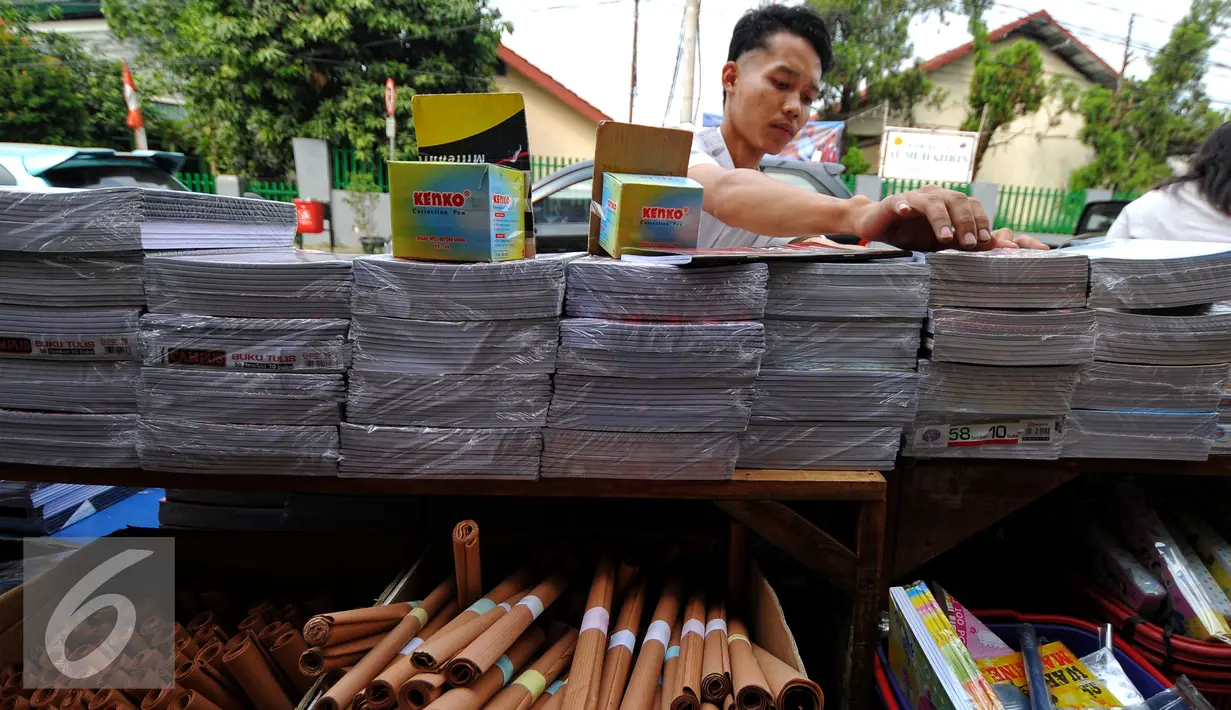 Seorang pedagang tampak merapikan barang dagangannya, Jakarta, Minggu (26/7/2015). Jelang tahun ajaran baru 2015/2016, penjualan buku tulis dan perlengkapan sekolah diperkirakan terus meningkat hingga Agustus mendatang. (Liputan6.com/Yoppy Renato)