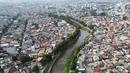 Aliran Sungai Ciliwung mengalir di antara permukiman warga di kawasan Bidara Cina, Jakarta, Rabu (28/6/2023). (Liputan6.com/Herman Zakharia)
