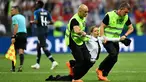 Petugas mengamankan seorang wanita yang menyusup masuk ke lapangan dalam laga final Piala Dunia 2018 antara Prancis dan Kroasia di Luzhniki Stadium, Minggu (15/7). Empat orang berlari masuk ke dalam lapangan menggangu jalannya laga. (AP/Martin Meissner)