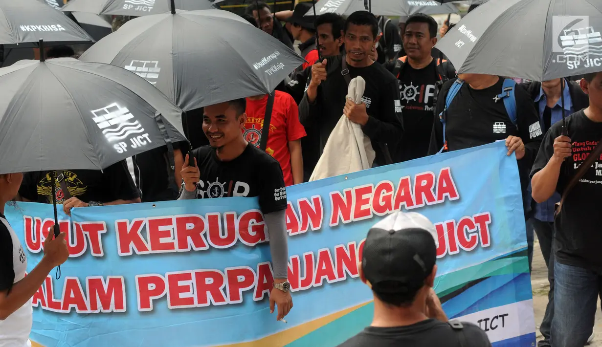 Massa Serikat Pekerja JICT dan FPPI berunjuk rasa di depan Gedung KPK, Jakarta, Selasa (18/12). Massa berunjuk rasa sambil mengenakan payung hitam. (Merdeka.com/Dwi Narwoko)