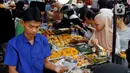 Pedagang melayani pembeli takjil menjelang waktu berbuka puasa di sepanjang Jalan Panjang, Kebon Jeruk, Jakarta, Selasa (4/4/2023). (Liputan6.com/Johan Tallo)