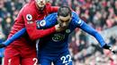 Pemain Chelsea, Hakim Ziyech, diadang pemain Liverpool,  Andrew Robertson, pada laga Liga Inggris di Stadion Anfield (21/1/2023). Impian Hakim Ziyech bermain bersama Lionel Messi, Neymar, Kylian Mbappe, dan sahabat baiknya Achraf Hakimi, gagal total. Transfernya sebagai pemain pinjaman ke PSG batal di akhir-akhir bursa transfer bulan Januari 2023 karena The Blues salah mengirim dokumen. (AFP/Paul Ellis)