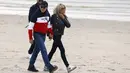 <p>Presiden Prancis Emmanuel Macron dan istrinya Brigitte Macron berjalan di sepanjang pantai di Le Touquet, menjelang putaran kedua pemilihan presiden Prancis, Sabtu (23/4/2022). Emmanuel Macron akan menghadapi Marine Le Pen dalam putaran kedua pemilihan presiden (pilpres) pada 24 April 2022. (Ludovic MARIN / AFP)</p>