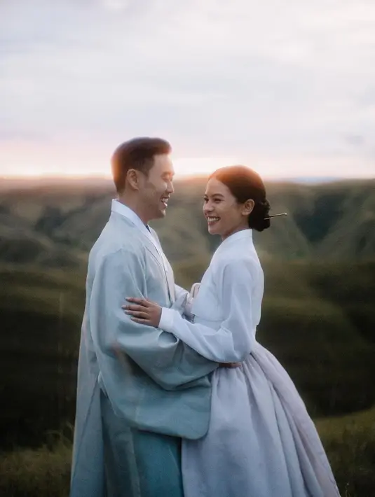 Di foto pre-weddingnya, Maudy Ayunda tampil mengenakan hanbok. Ia tampil melokal dengan latar pemandangan bukit, Maudy mengenakan hanbok bernuansa putih dengan siluet klasik, rambutnya pun digulung bak putri kerajaan Joseon. [Foto: Instagram/maudyayunda]