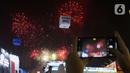 Pengunjung mengambil gambar pesta kembang api di langit saat Jakarta Fair ke-53 atau Pekan Raya Jakarta (PRJ) di JiExpo Kemayoran, Jakarta Pusat, Selasa (21/6/2022) malam. Pesta kembang api menggelegar di kawasan PRJ bertepatan dengan HUT Jakarta yang jatuh pada besok, 22 Juni 2022. (Liputan6.com/Herman Zakharia)