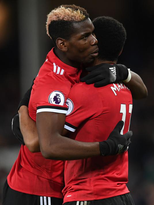 Striker Manchester United, Anthony Martial berpelukan dengan Paul Pogba merayakan gol pertama untuk timnnya saat melawan Everton dalam pertandingan Liga Inggris di Goodison Park, Liverpool (1/1). (AFP Photo/Paul Ellis)