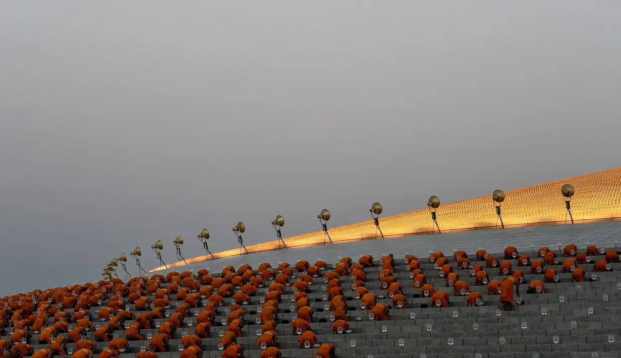 Biksu berdoa selama ritual Makha Bucha Day di kuil Wat Dhammakaya, Bangkok, Thailand (11/2). Makha Bucha atau Magha Puja berarti puja/peringatan yang berhubungan dengan bulan Magha. (AFP/Lillian Suwanrumpha)