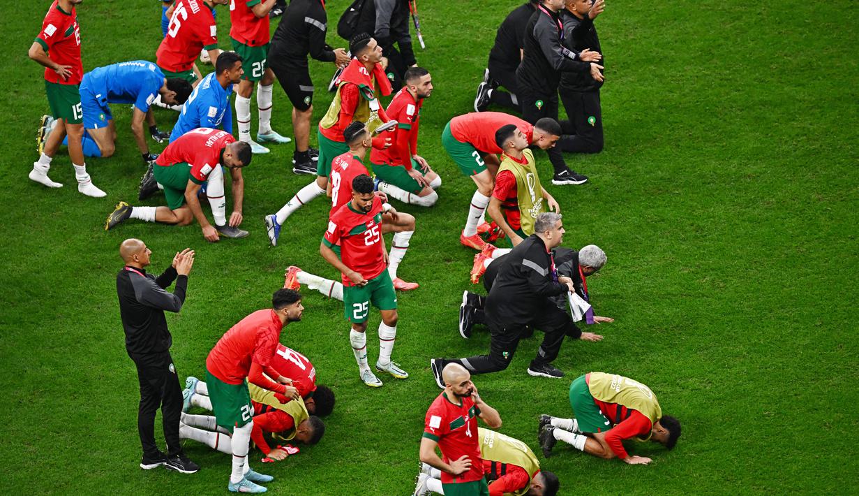 Meski pada laga tersebut mereka tumbang dua gol tanpa balas, namun para pemain beserta staf timnas Maroko tetap melakukan sujud syukur seperti yang biasa mereka lakukan sebelumnya. (AFP/Anne-Christine Poujoulat)