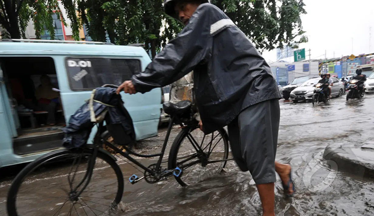 Seorang pengendara sepeda tampak melintas di Jalan Iskandar. Sistem drainase yang buruk menjadi penyebab sejumlah ruas jalan di Ibu Kota selalu digenangi air setiap turun hujan, Jakarta, Kamis (22/1/2015).(Liputan6.com/Miftahul Hayat)