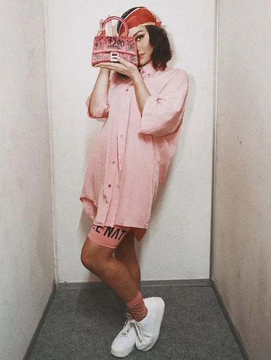 Kenakan pakaian serba pink, dari kemaja loose, dipadu dengan cycling short. Agnezmo membawa handbag pink Balenciaga seharga Rp28 jutaan. @agnezmo.