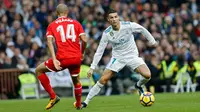 Pemain Real Madrid, Cristiano Ronaldo berebut bola dengan pemain Sevilla, Guido Pizarrodalam lanjutan pekan ke-15 Liga Spanyol di Santiago Bernabeu, Sabtu (9/12). Real Madrid membantai tamunya Sevilla dengan skor 5-0. (AP/Francisco Seco)