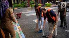 Sejumlah warga yang terjaring dalam razia penggunaan masker dihukum menyapu di Kelurahan Cimone, Kota Tangerang, Banten, Rabu (15/7/2020). Pemerintah Kota Tangerang memberlakukan sanksi sosial kepada pelanggar PSBB. (Liputan6.com/Angga Yuniar)
